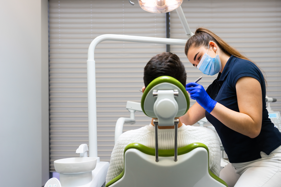Dental patient getting an exam in the dental chair from a dental assistant.