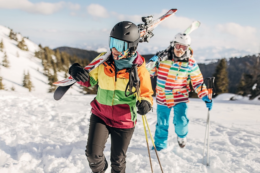 Two children carrying their skies up the mountain.