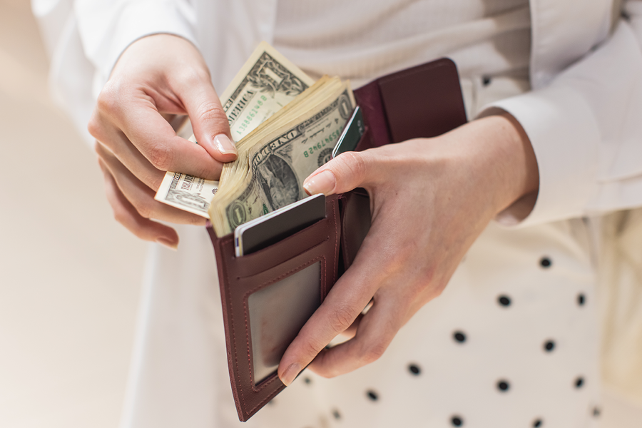 Person taking money out of their wallet.