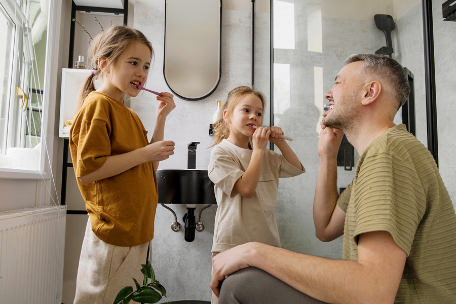 Father and daughter brushing their teeth.